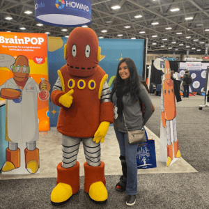 Teacher posing for a picture with BrainPop's mascot, Moby.