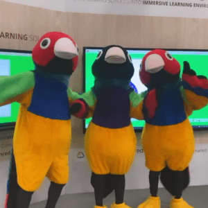 Three bird mascots pose for a picture in the exhibit hall