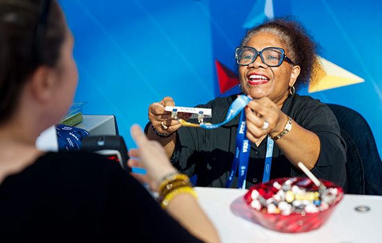 Volunteer helping an educator with her registration badge at the TCEA Convention & Exposition.